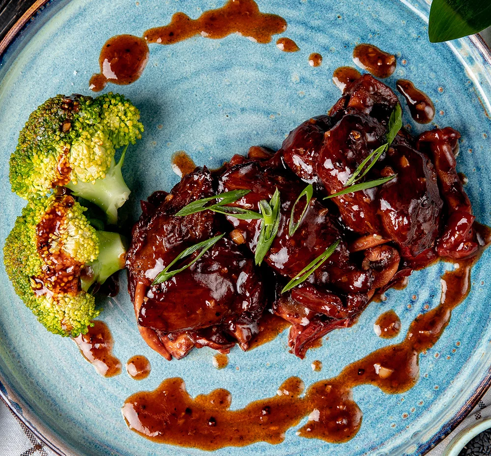 Stoofvlees met saus en broccoli op een blauw bord bij De Gribus, restaurant Kootwijkerbroek dichtbij